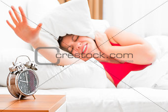 girl in bed and alarm clock on the bedside table