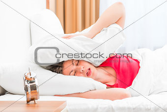 woman covering her ears pillows and fell asleep