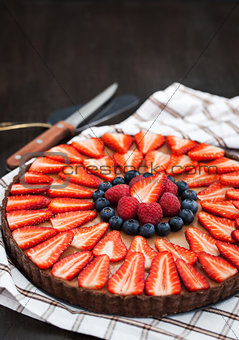 Delicious chocolate tart decorated with fresh berries