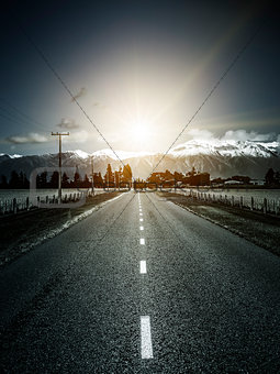road to the alps with dramatic sun light