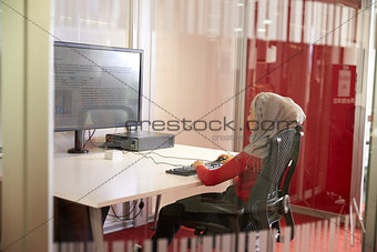 Female Student Working In Classroom With Large Screen