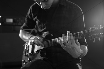 Close Up Of Man Using Tapping Technique On Electric Guitar