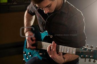 Man Playing Electric Guitar In Studio