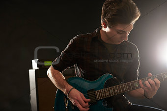 Man Playing Electric Guitar In Studio