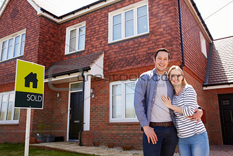 Portrait Of Young Couple Standing Outside New Home