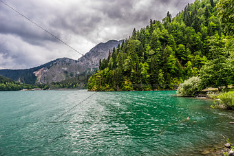 The emerald green lake framed by the forest and mountains