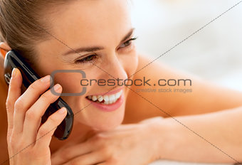 young woman laying on massage table and talking cell