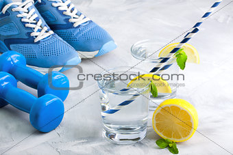 Sport composition with sports equipment glass water with lemon m