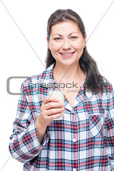 Portrait of a brunette in pajamas with a glass of milk isolated