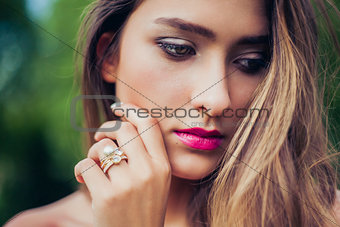 Portrait of beautiful girl with professional makeup. Stacking rings jewelry