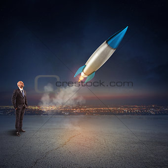 Businessman looks start a missile. Concept of company startup and new business. 3D Rendering.