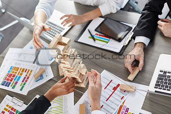 Team of business people build a wooden construction. concept of teamwork and partnership
