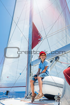 Little boy captain on board of sailing yacht on summer cruise. Travel adventure, yachting with child on family vacation.