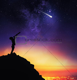 Child observes starry sky with a telescope