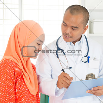 Medical doctor showing report to patient.