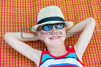 6 year old boy resting on the beach, top view