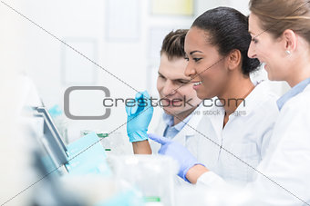 Group of researchers during work on devices in laboratory