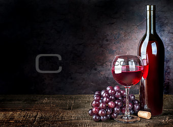 Glass of red wine with grapes and bottle