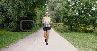 Cheerful woman running in park