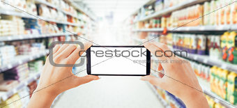 Woman using a smartphone at the supermarket