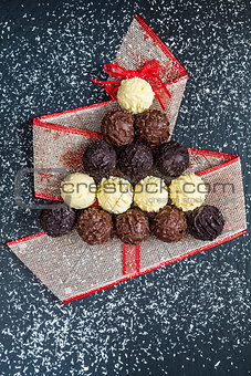 Chocolate pralines shape Christmas tree on black