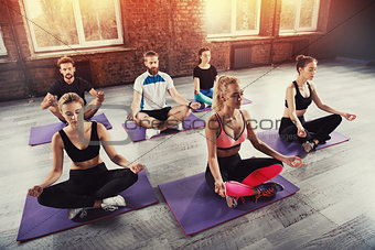 Yoga meditation of young people in lotus pose in fitness center