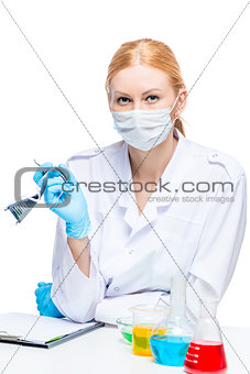 young laboratory girl at a table with test tubes posing