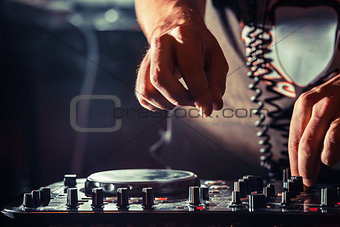 DJ playing music at mixer, hands closeup