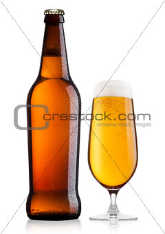 Cold bottle and glass of lager beer with foam 