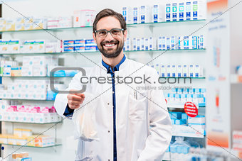 Pharmacist in pharmacy selling pharmaceuticals in bag