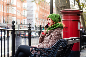 Young London lifestyle woman Talking on Mobile with red postbox 