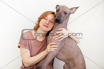 A woman hugging with a Mexican Hairless Dog