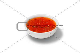 Chilli sauce in a gravy boat on white background