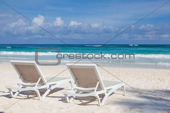 Two white beach chairs on the empty beach , Yucatan, Mexico