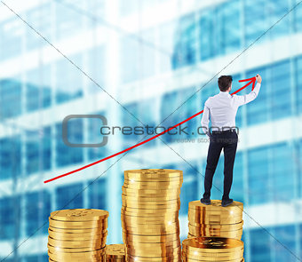 Businessman draws growing arrow of company statistics over a pile of money