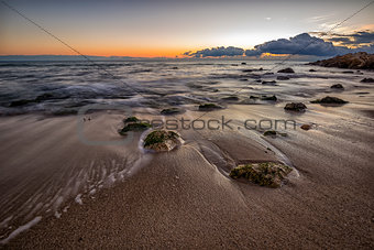 early morning at sea shore with stones on the beach