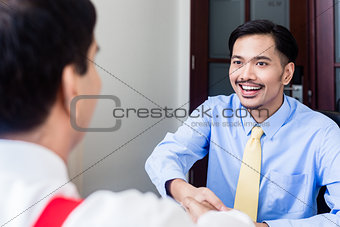 Subordinate professional talks to supervisor in office building