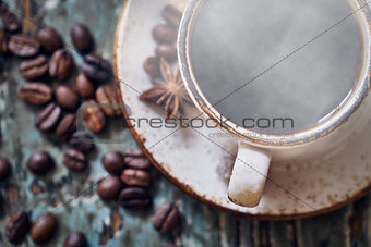 Cup of hot steaming coffee on wooden table