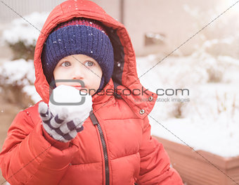 infant holding in his hand a snowbal