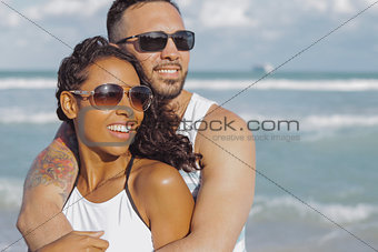 Embracing stylish couple on ocean shore