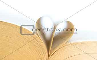 Book with opened pages of shape of heart isolated on white background. Love read concept. Knowledge symbol. Book day