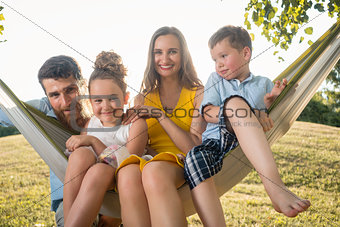 Family portrait with beautiful mother of two children next to her husband