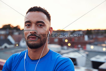 Male runner in urban setting looking to camera, close up