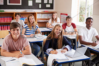 Portrait Of Students Sitting At Desks In Classroom