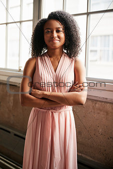 Young black businesswoman with arms crossed smiles to camera