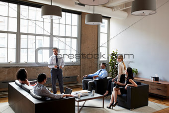Businessman presenting at an informal meeting, wide shot
