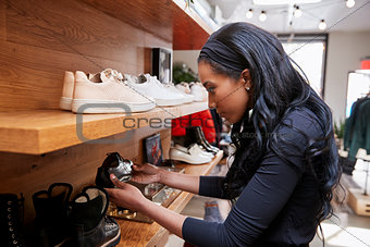 Young woman looking at shoes on display in a shop, close up