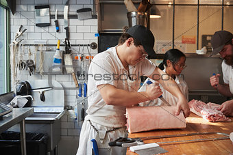 Three butchers preparing meat,cuts of meat at a butcher's shop