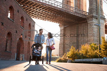 Young family with a daughter taking walk on a street