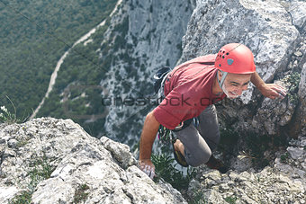 old-aged man rock climber climbs on the cliff